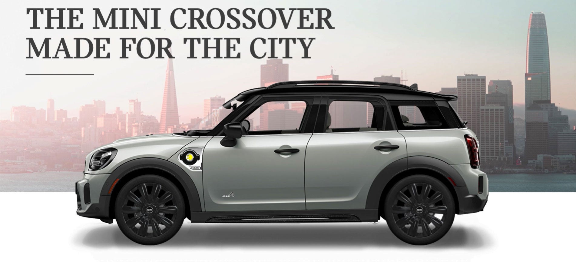 The MINI Cooper SE Countryman PHEV parked in front of a city scape. MINI of Bedford in Bedford NH