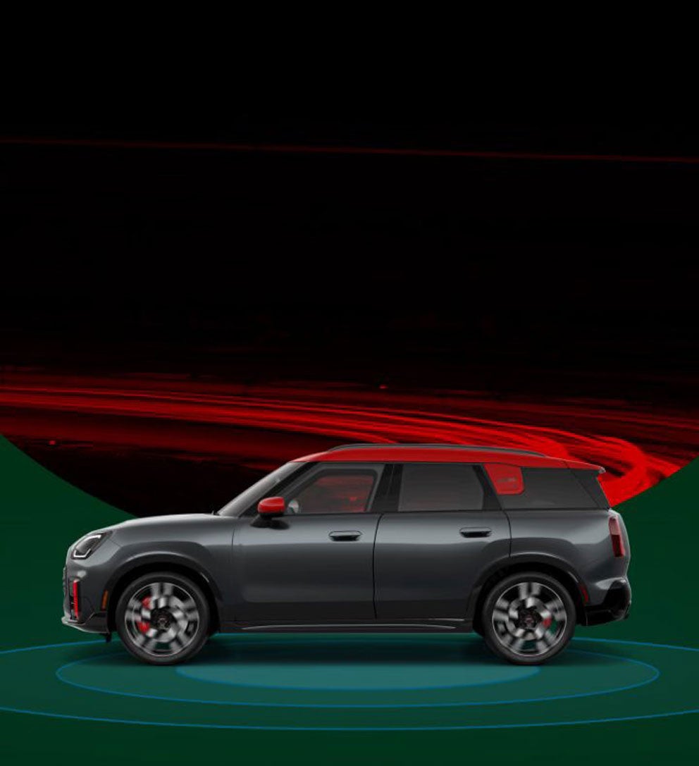 The side-view of a 2025 MINI JCW Countryman ALL4 with blue rings beneath it against a background of red and black rings.